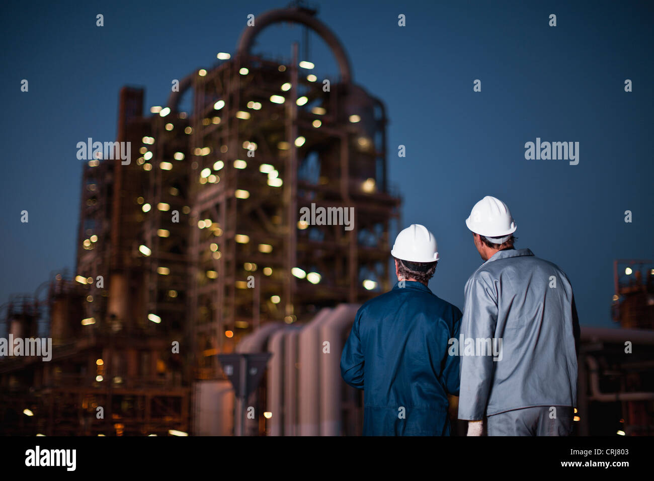 Workers standing at oil refinery Stock Photo