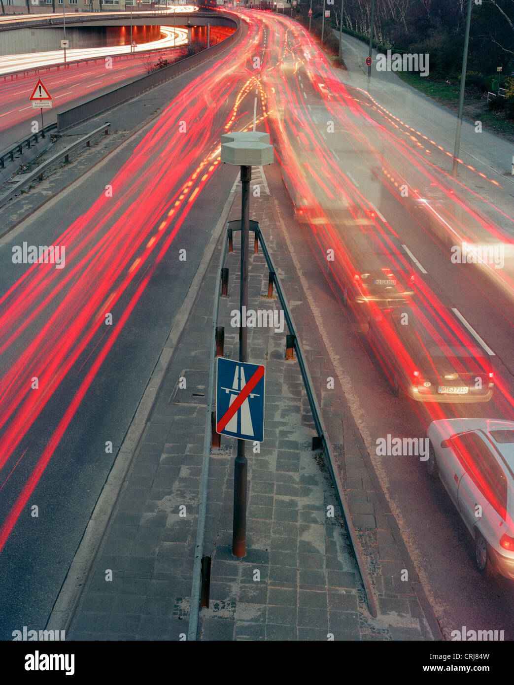 Light trails of vehicles on a freeway exit in the dusk Stock Photo
