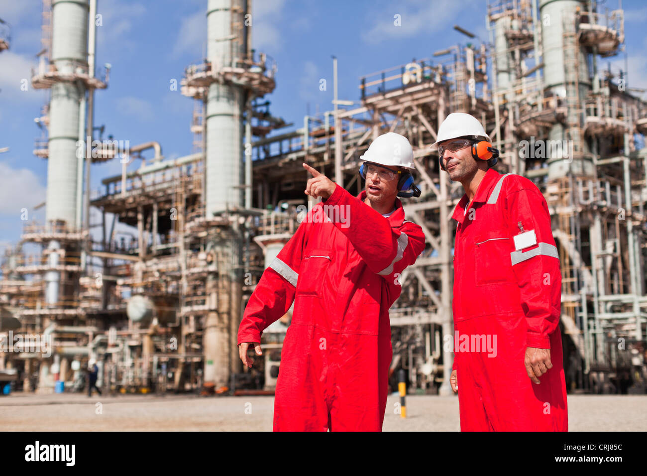 Workers talking at oil refinery Stock Photo