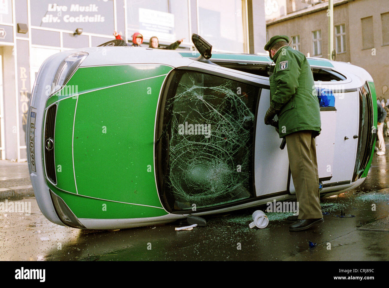 A policeman in front of his destroyed car radio in Berlin Stock Photo