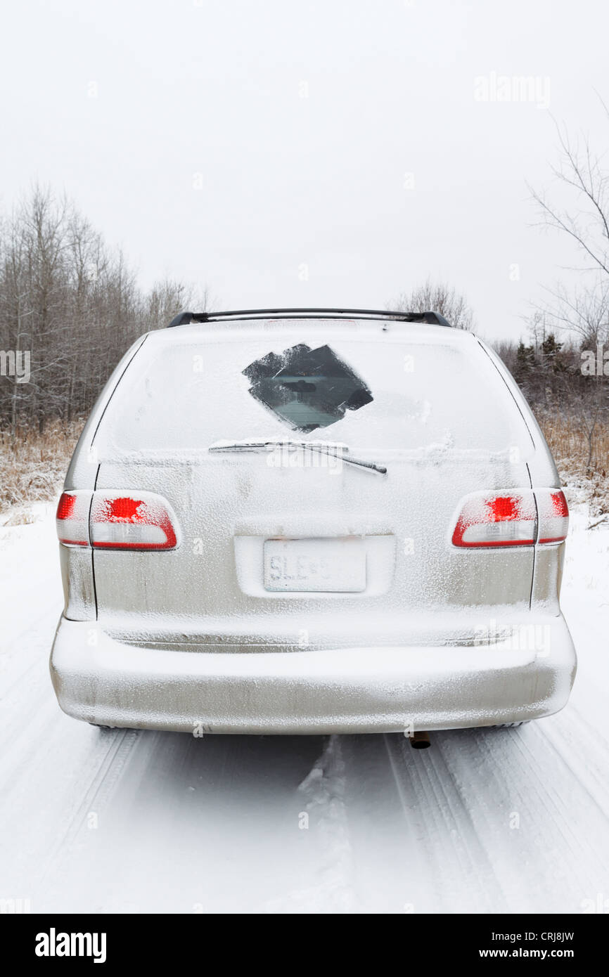 A minivan in winter headed down a lonely road. Stock Photo