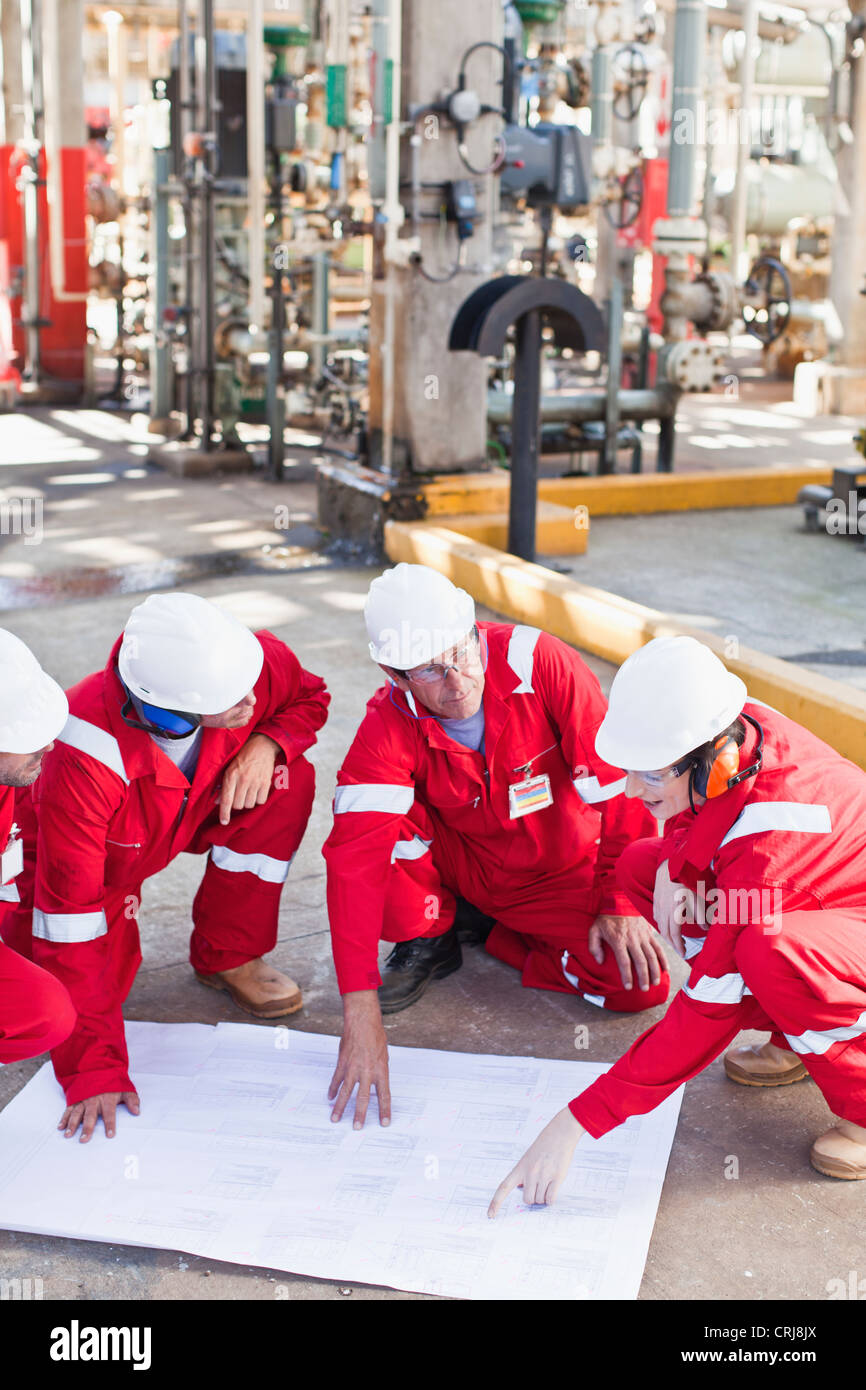 Workers with blueprints at oil refinery Stock Photo - Alamy