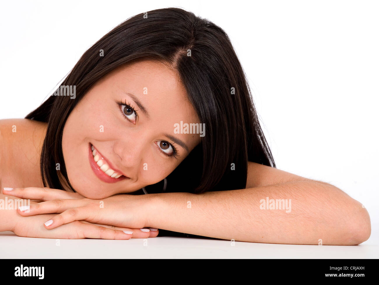 smiling young girl with the head laid on her arms Stock Photo