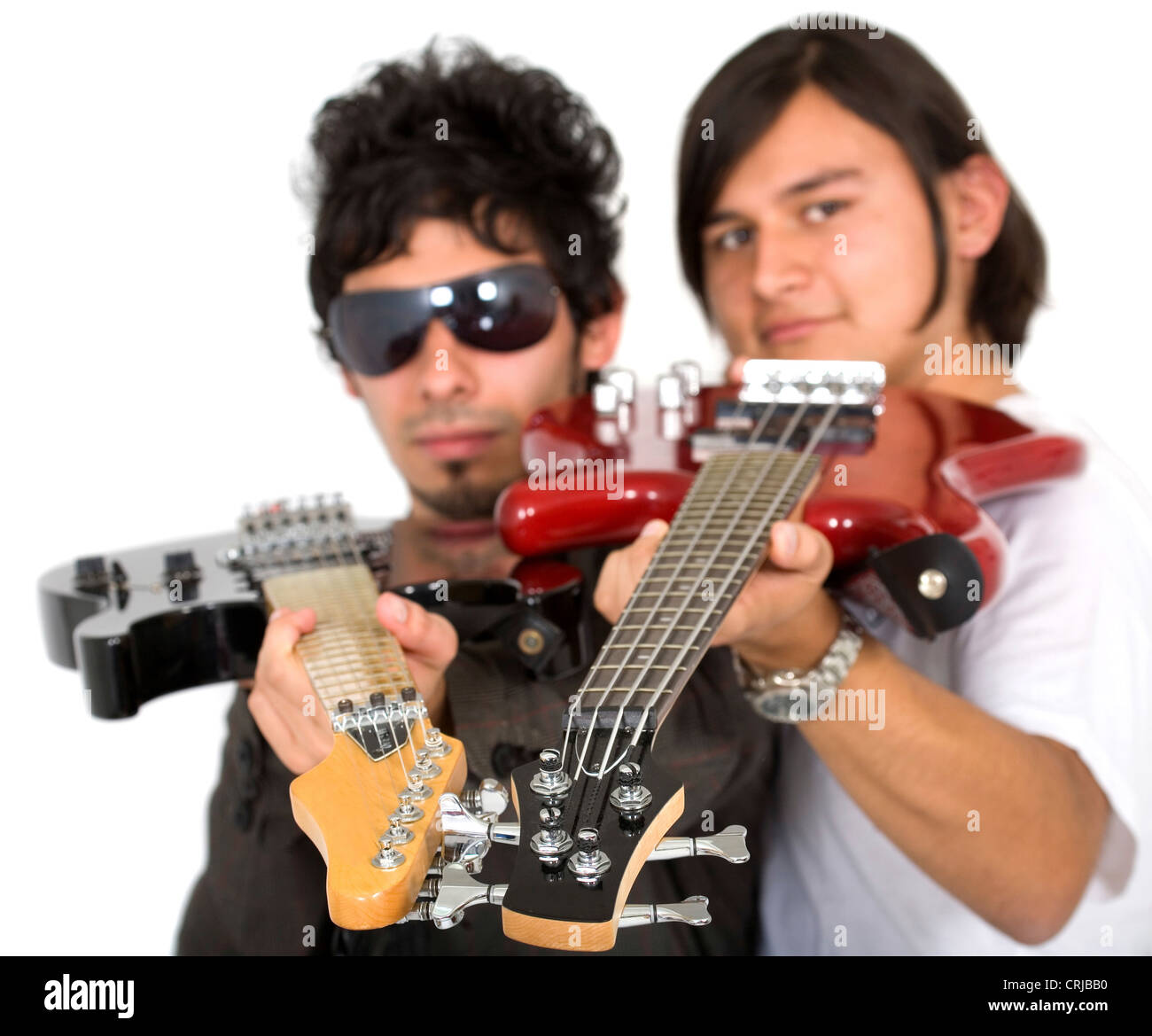 guitarist and bassist of a band aiming at the camera with the necks of