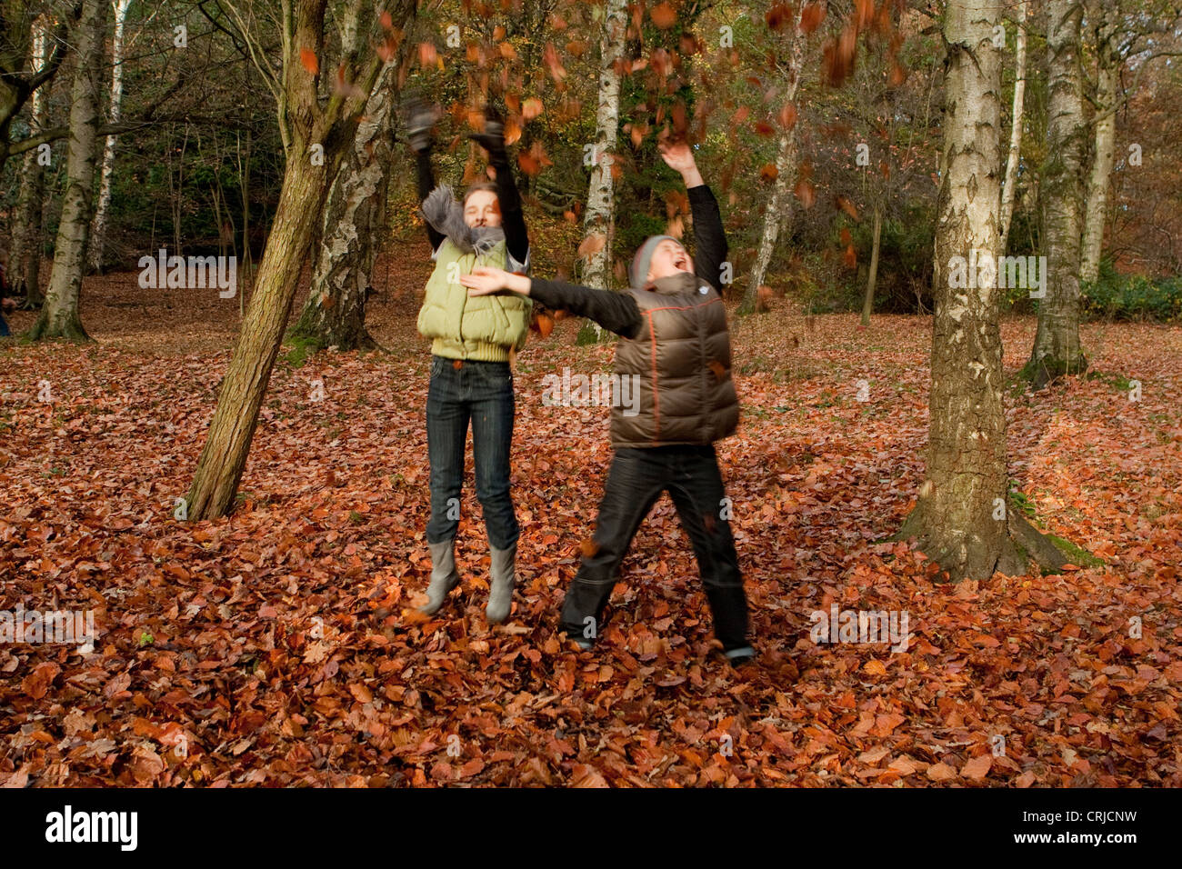 Happy children playing with autumn leaves in a park Stock Photo - Alamy