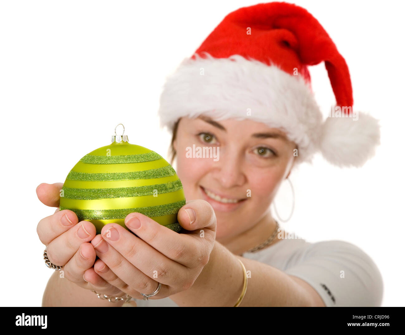 beautiful girl wearing a christmas hat looking at a Christmas tree ball Stock Photo