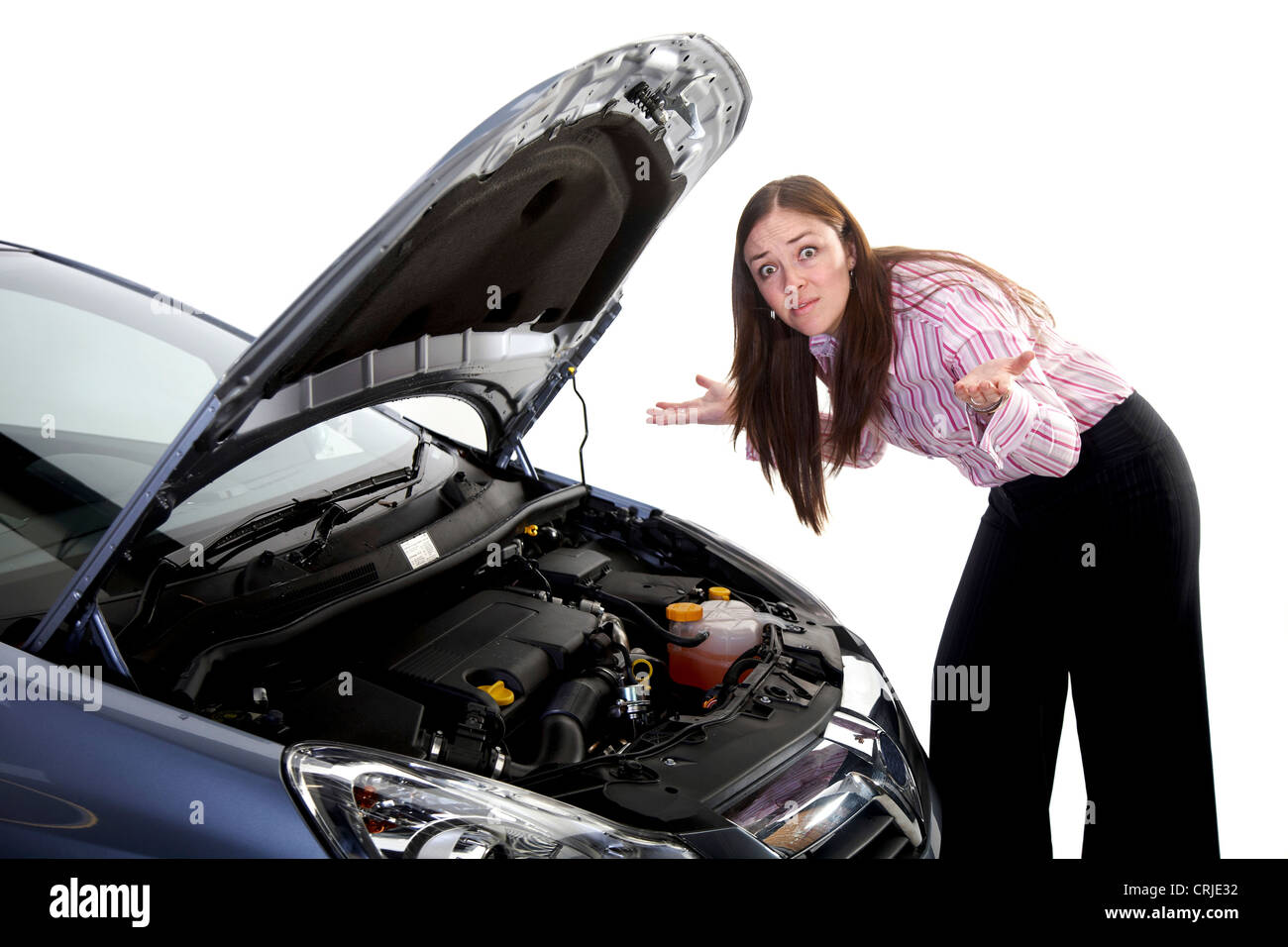 young woman with a capitulating gesture in front of the open engine bonnet of a car Stock Photo