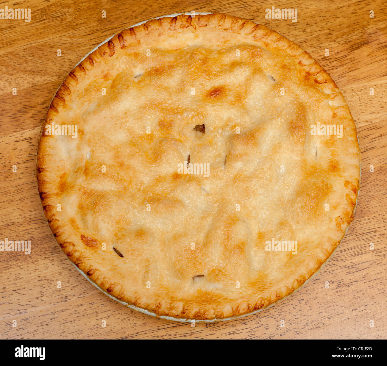 Freshly baked hot apple pie on wooden table Stock Photo