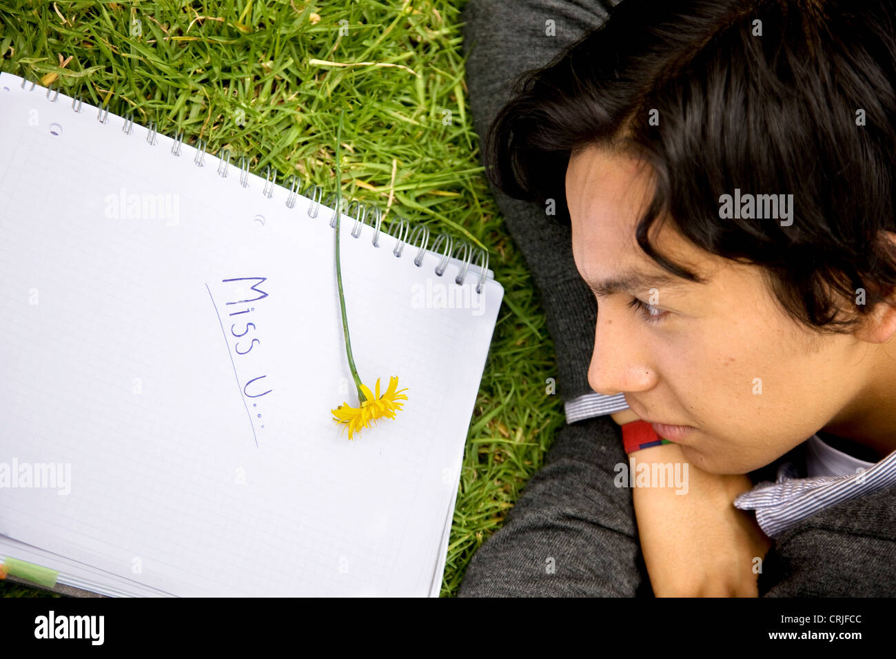 boyfriend missing his girlfriend - 'miss u' written on notebook Stock Photo