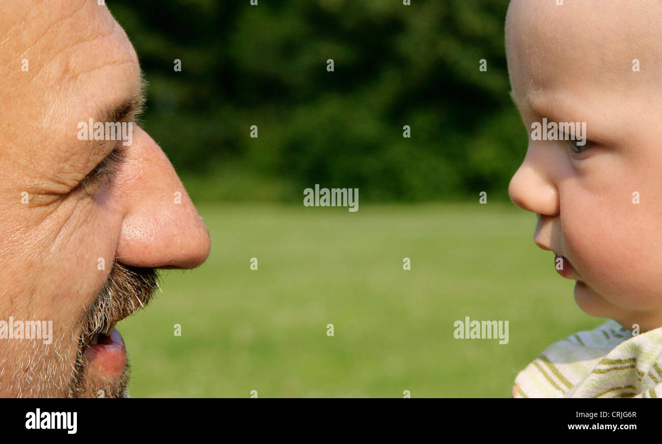 grandfather and grandson looking eachother in the eyes, Germany Stock Photo