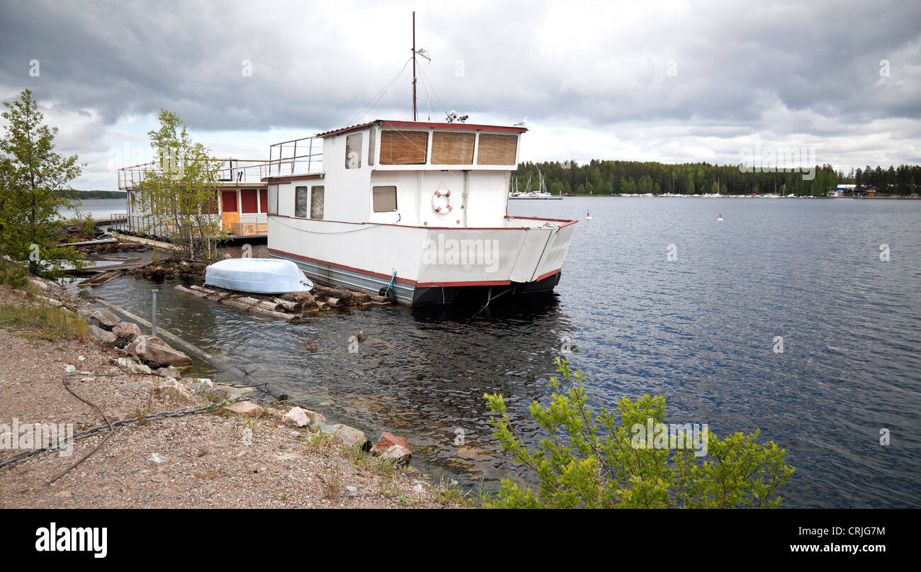 Small white boat moored on lake in Imatra town, Finland Stock Photo