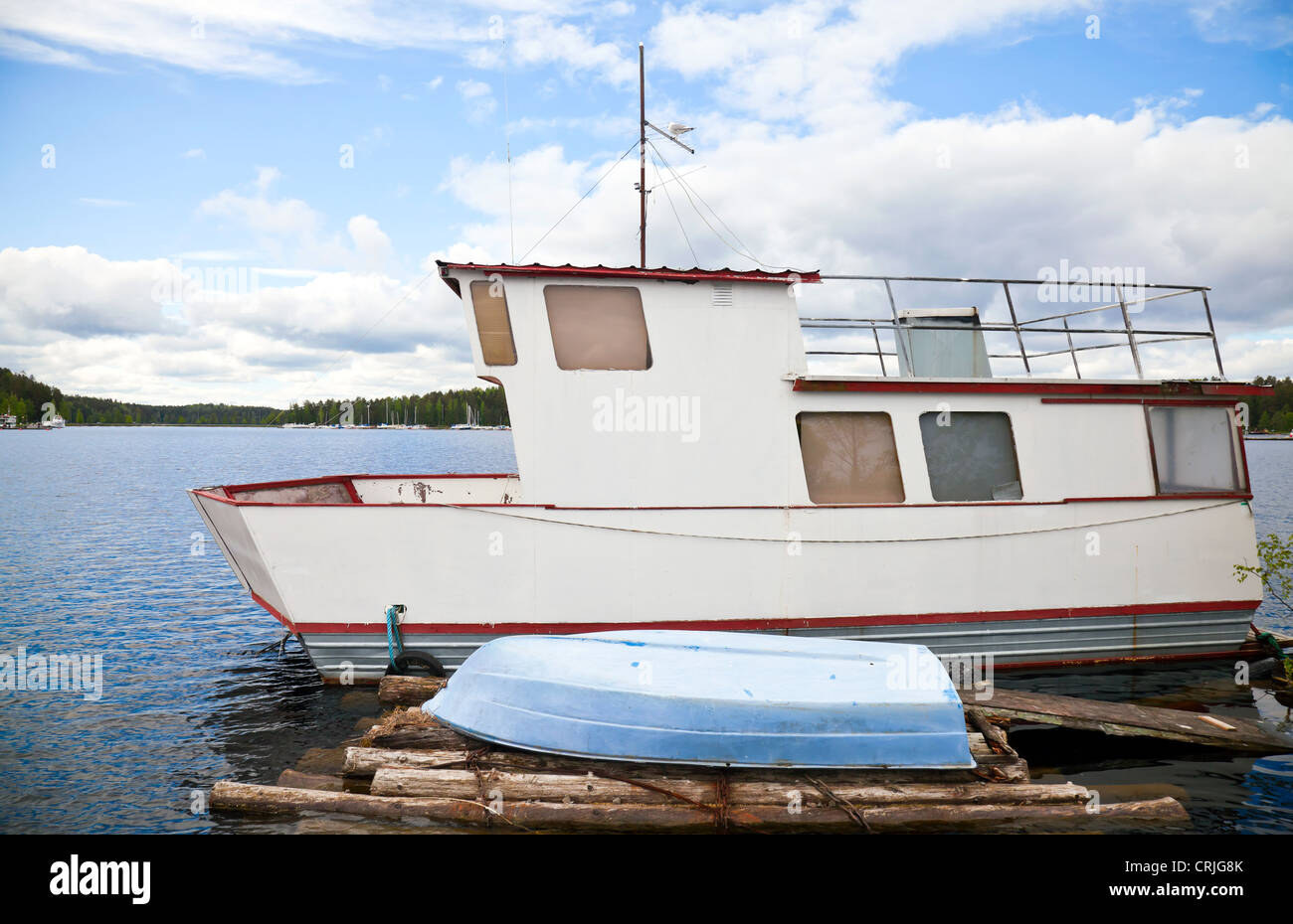 Small white boat moored on lake in Imatra town, Finland Stock Photo