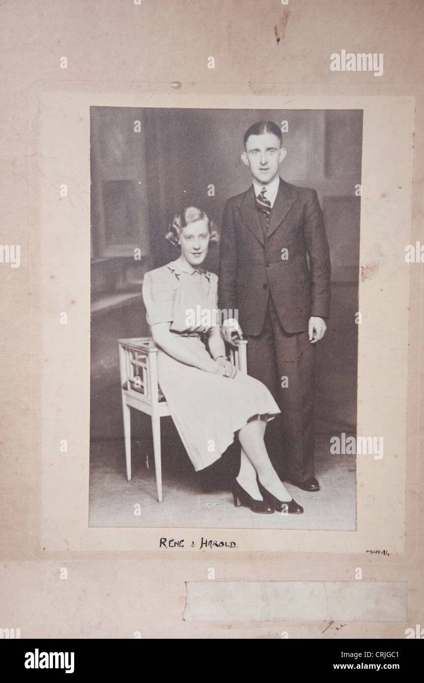 Old vintage photograph of 1930s couple posing formally, with original aged mount frame surround. Stock Photo