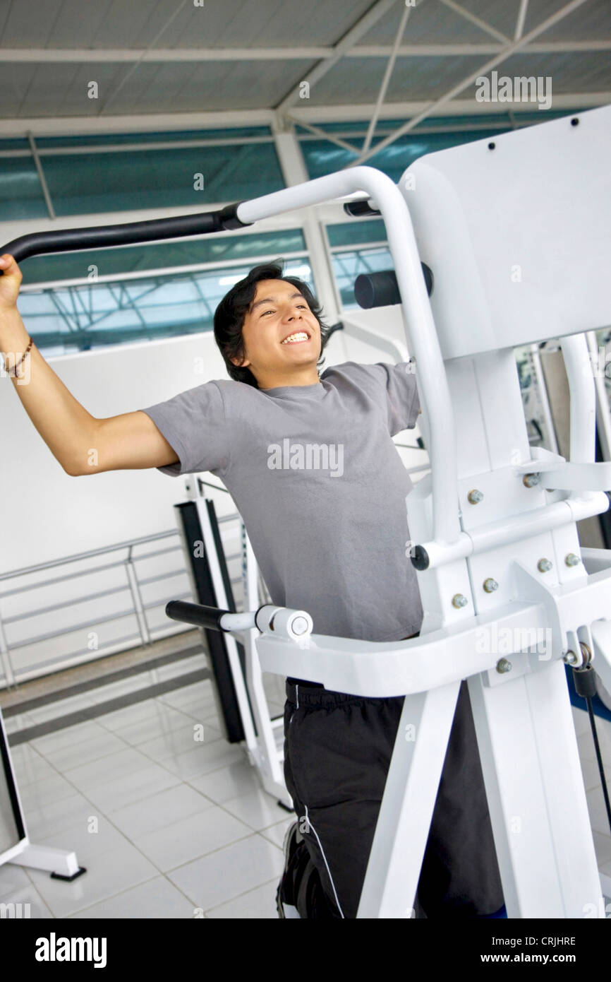 Young man at the gym doing chin ups Stock Photo