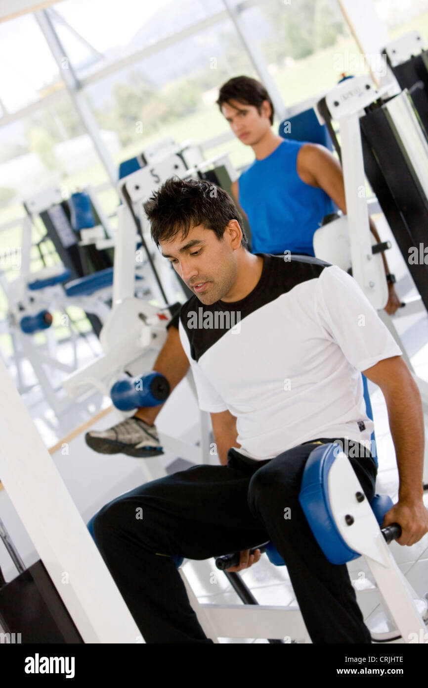 man at the gym doing exercise on a machine with weight Stock Photo