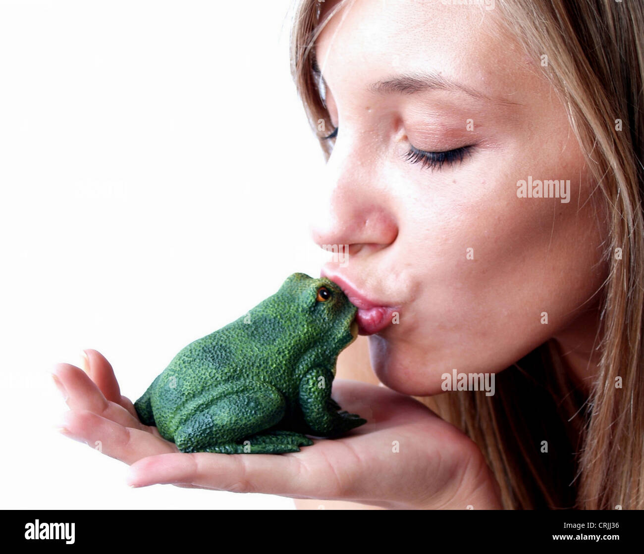 youn woman kissing a frog Stock Photo