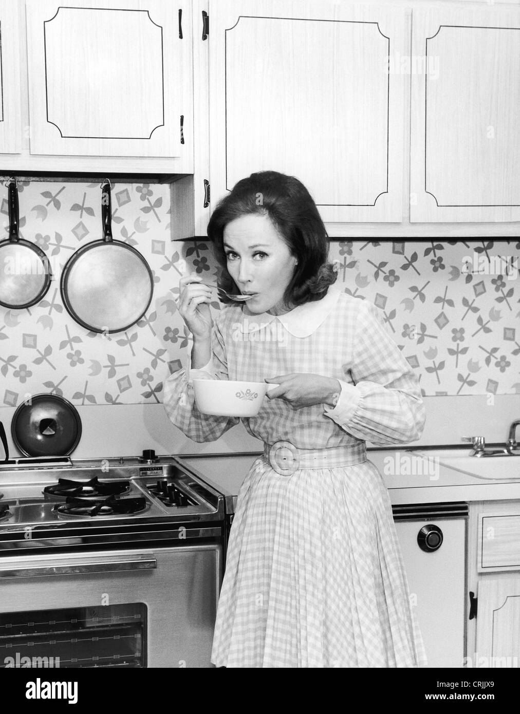 Homemaker tasting food from cooking pot Stock Photo
