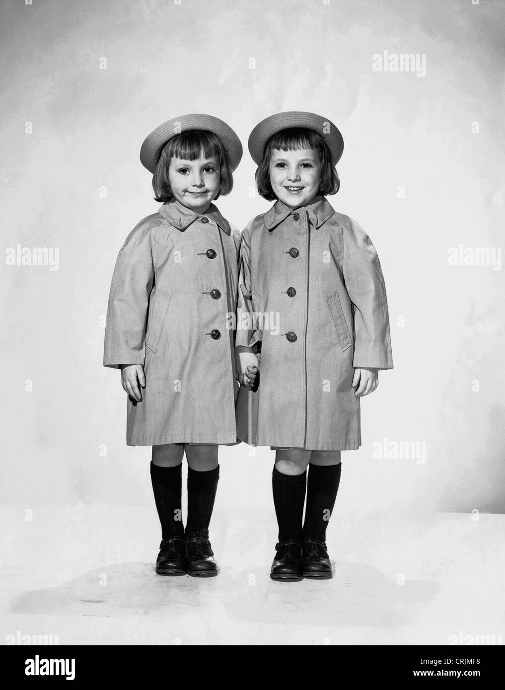 Portrait of twin girls in raincoats Stock Photo