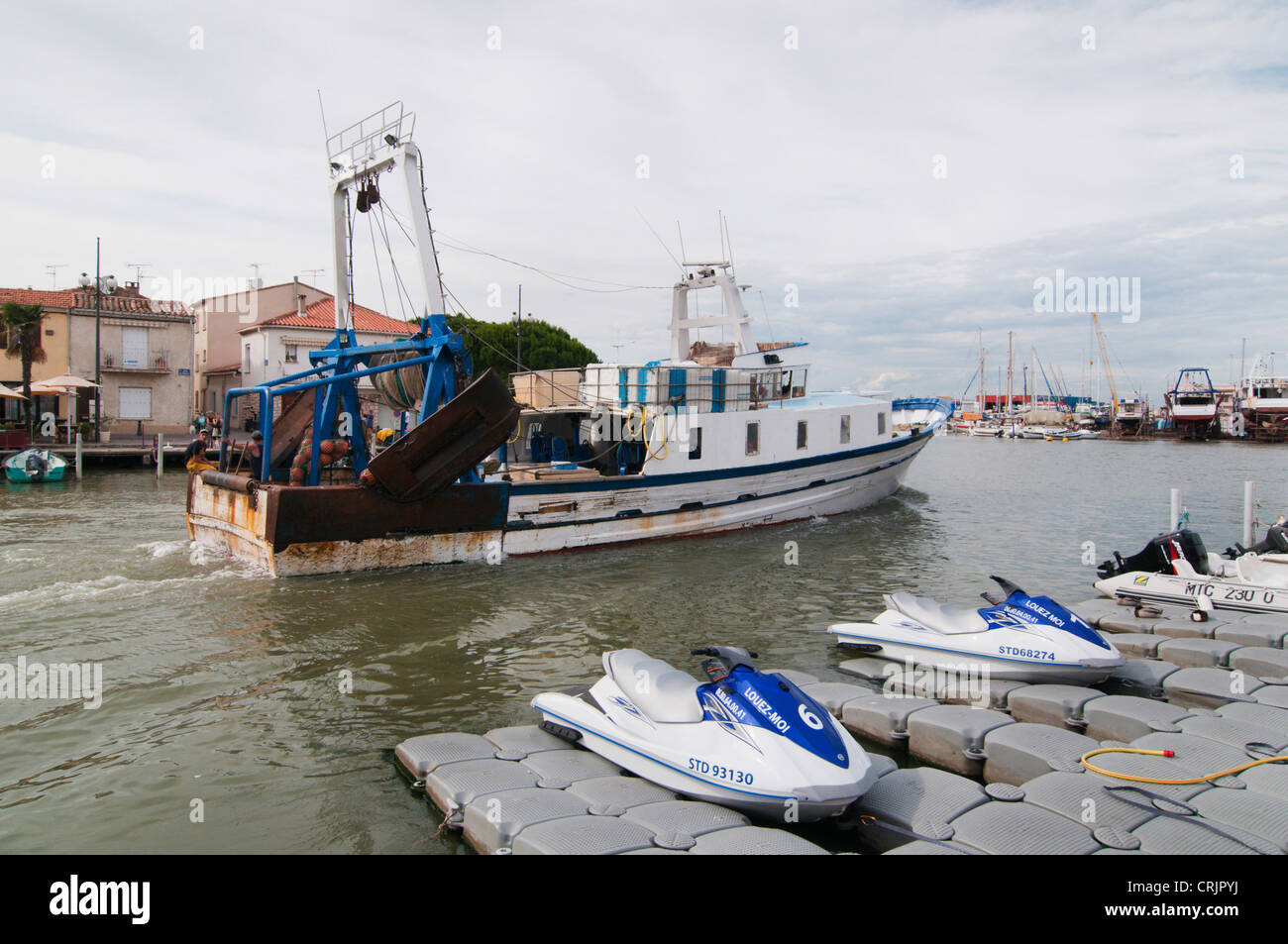 fishing trawler passing the chanal in Le Grau-du-Roi, with Jet Skis in the  foreground, France, Languedoc-Roussillon, Camargue, Le Grau-du-Roi Stock  Photo - Alamy