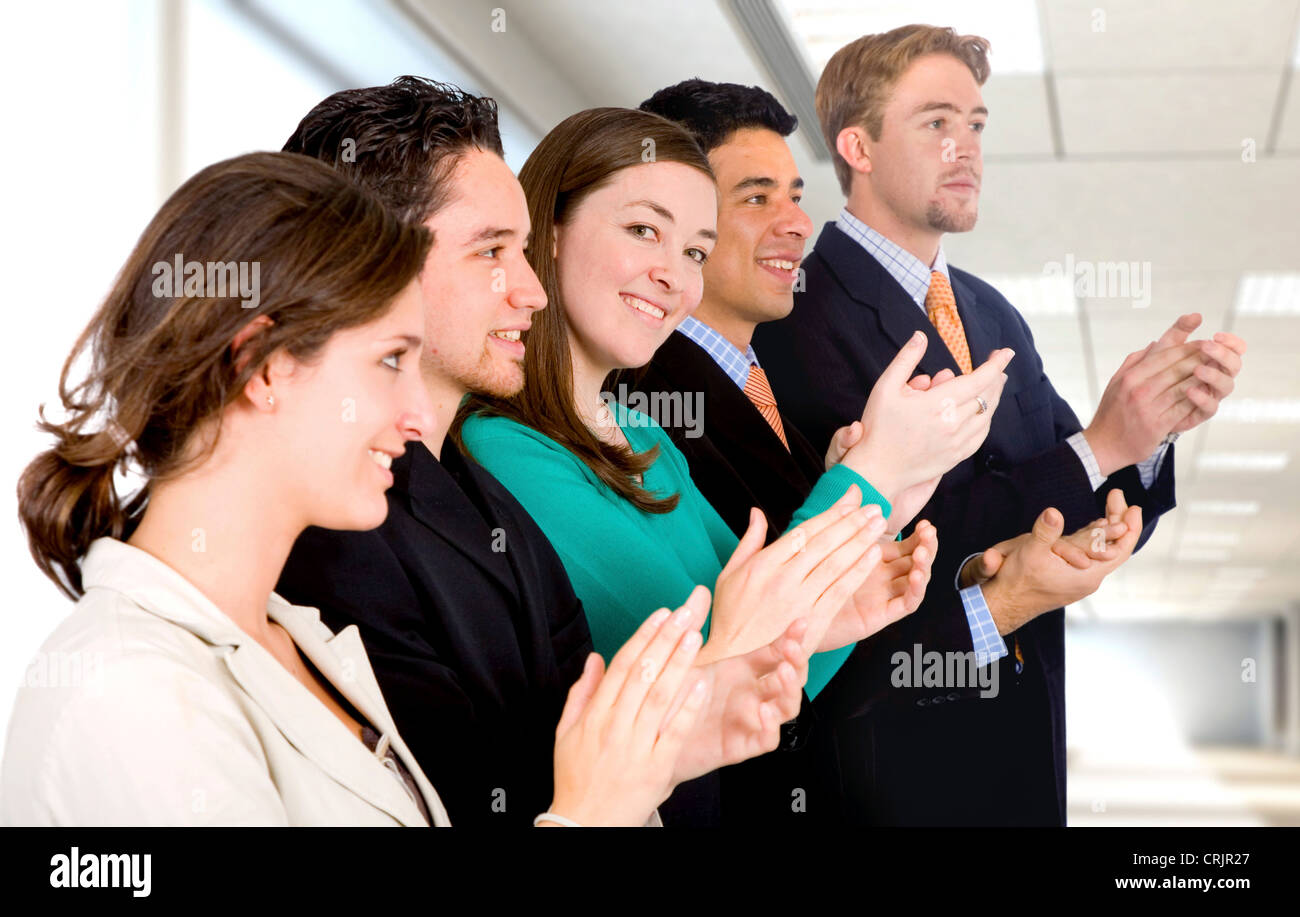 group of business people in an office applauding and smiling at success Stock Photo