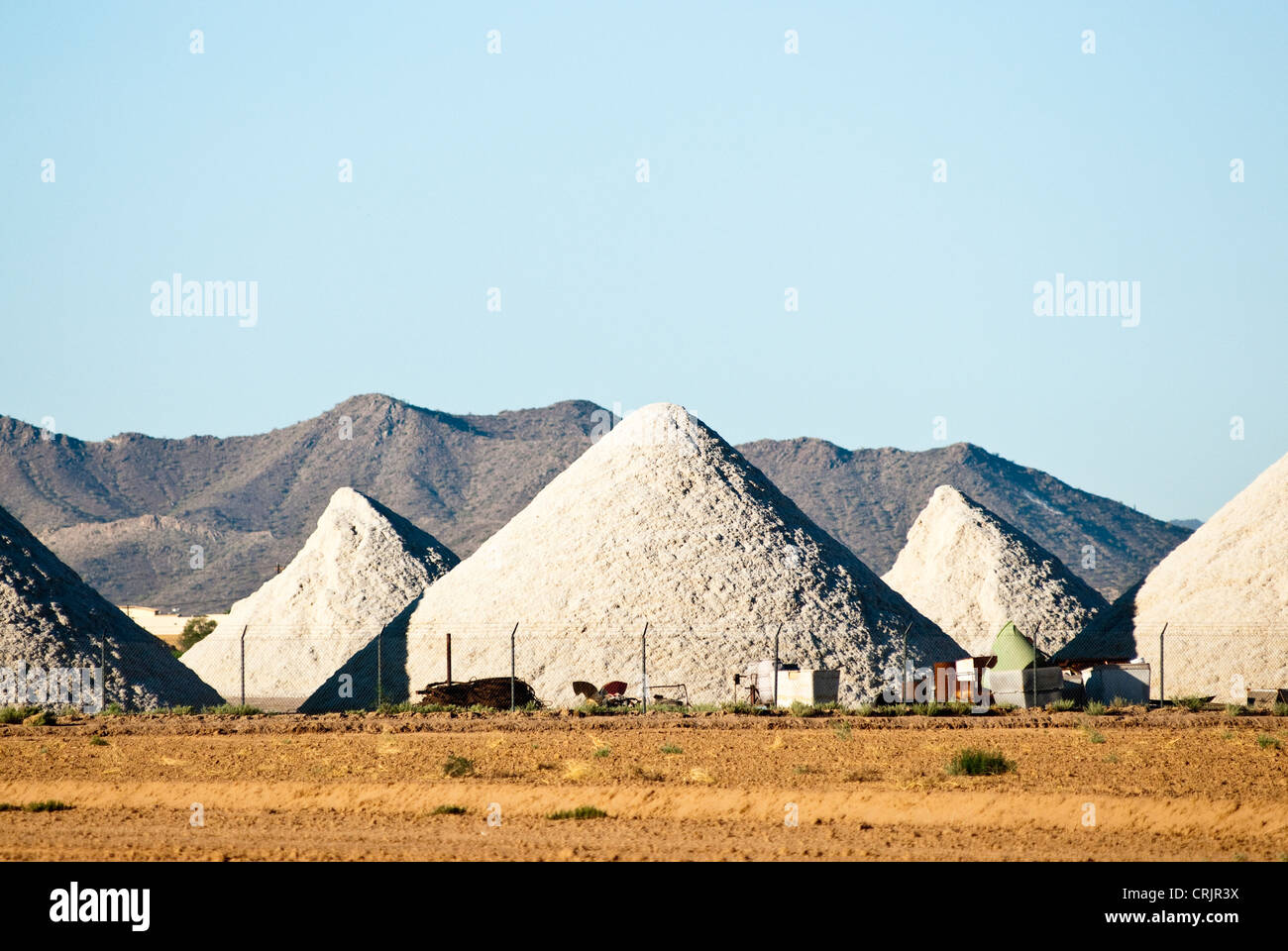 Piles of cotton processed cotton seed are shown at a cotton gin. Stock Photo