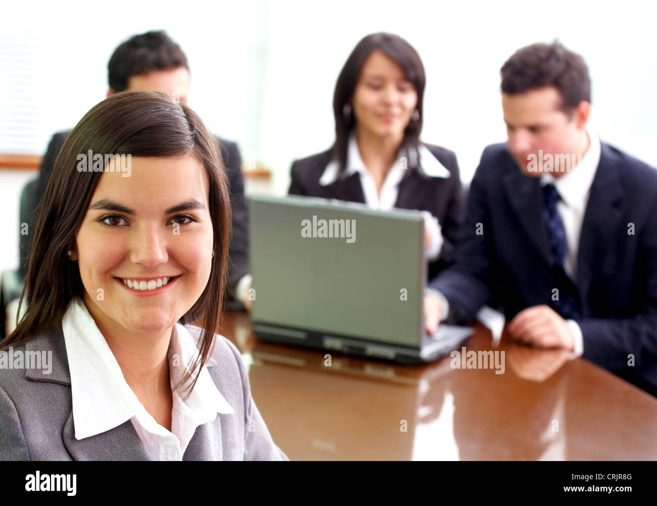 business woman in an office environment with people working behind her Stock Photo