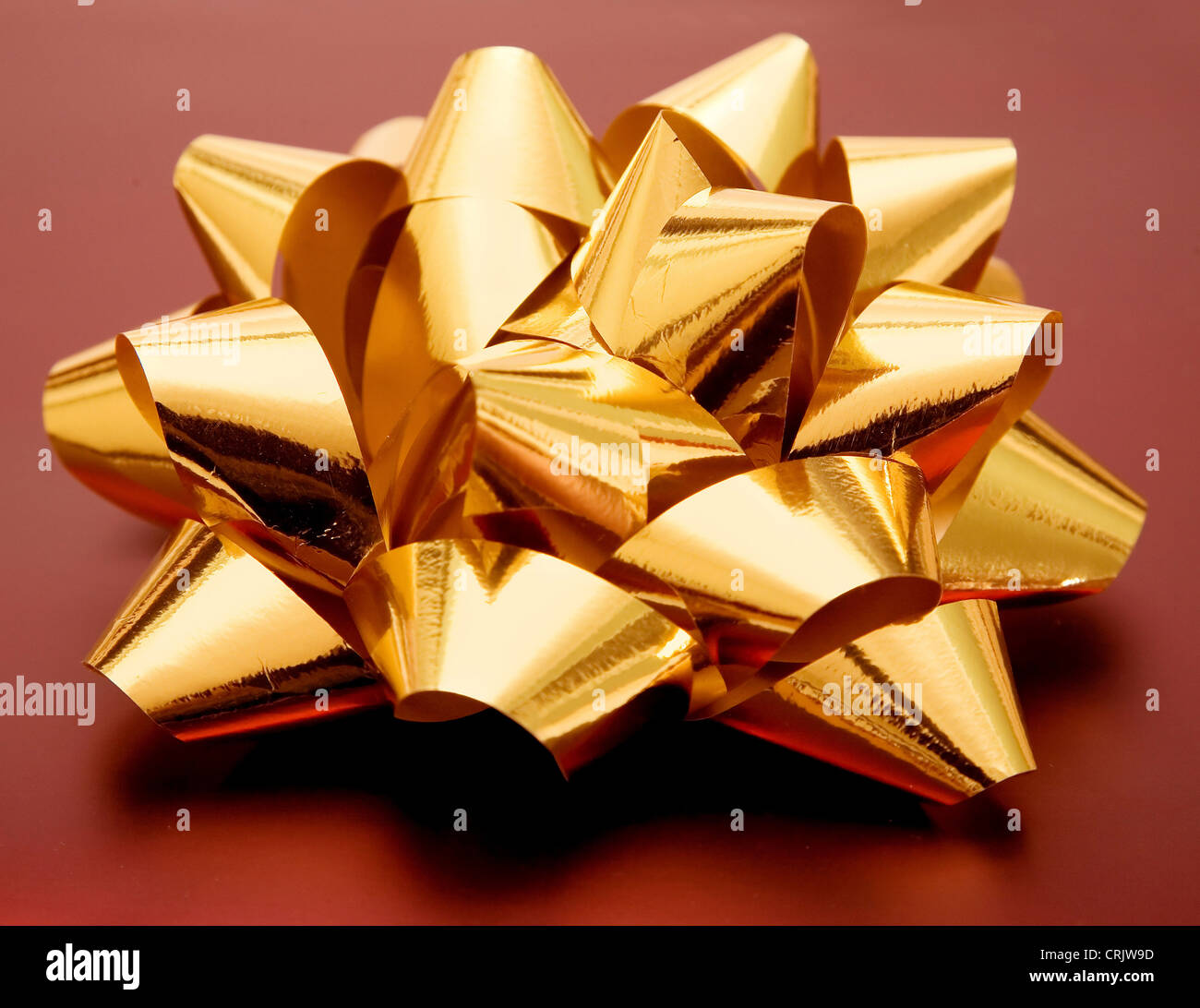 golden gift ribbon placed on a dark red present Stock Photo