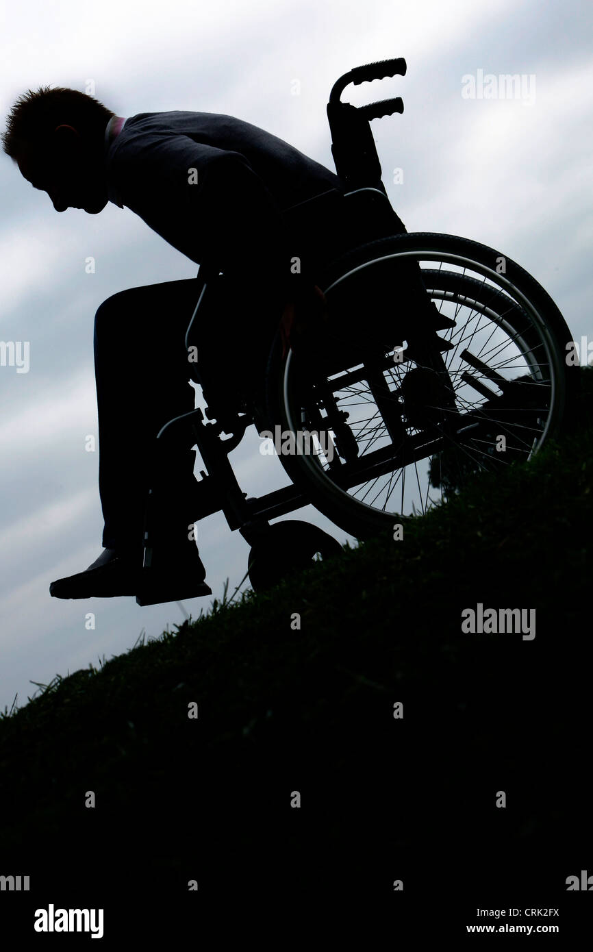 A Man Wheelchair bound, wheeling through a park Stock Photo Alamy
