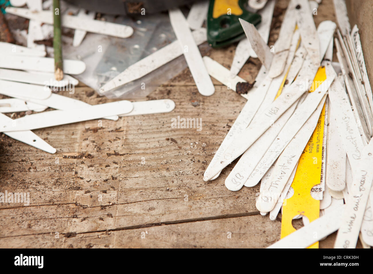 A wooden bench covered in plastic plant pot labels Stock Photo