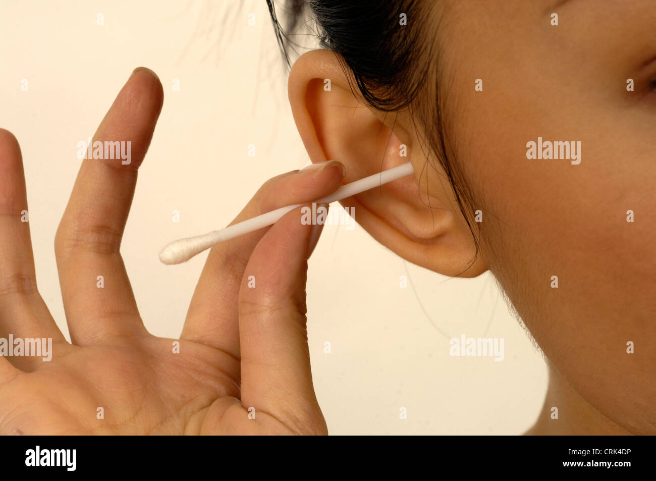 A woman is cleaning her ear with a cotton bud Stock Photo Alamy