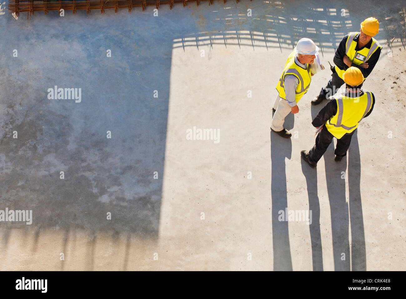 Workers casting shadows on site Stock Photo