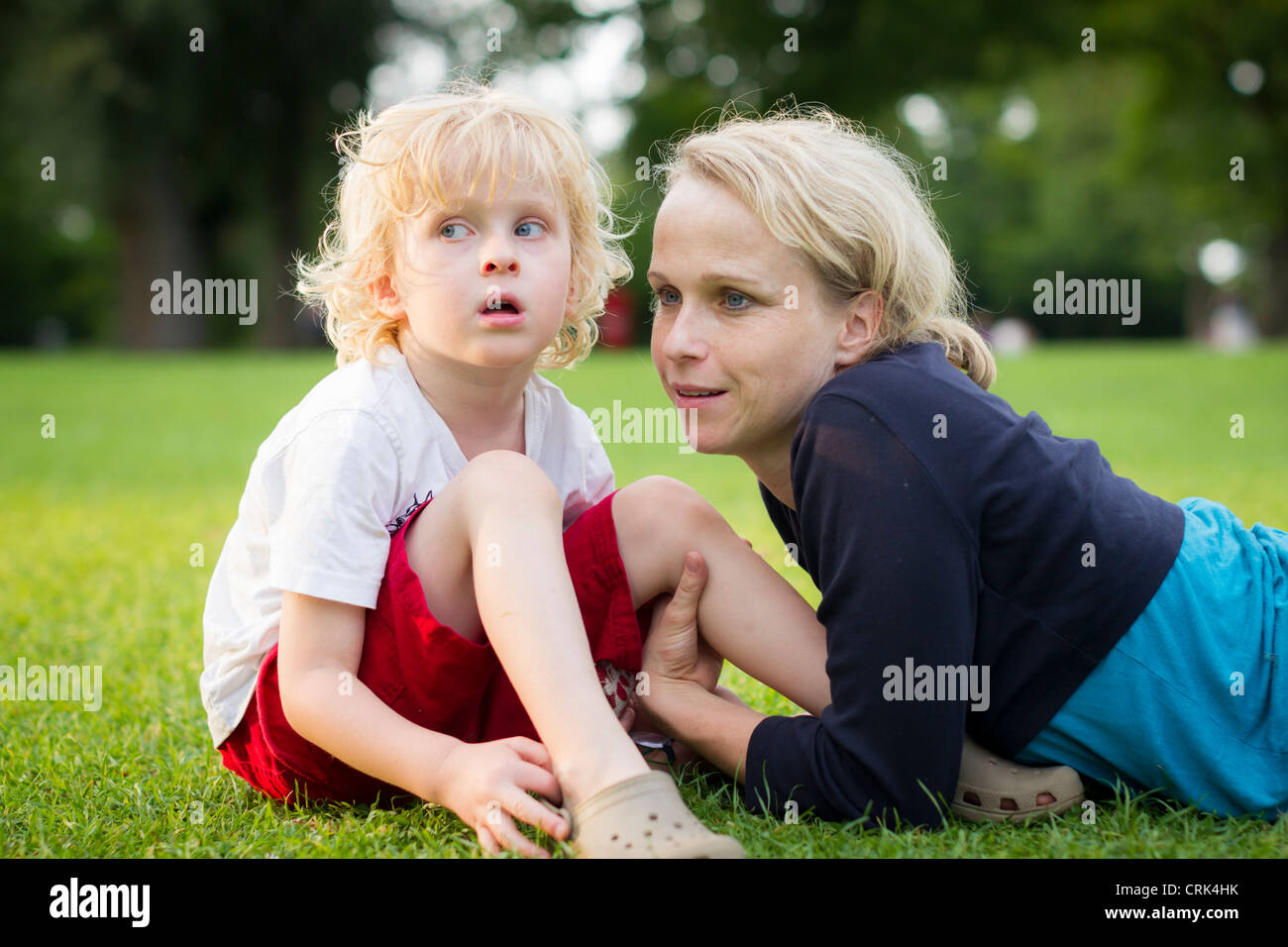 Mother and son sitting in grass Stock Photo