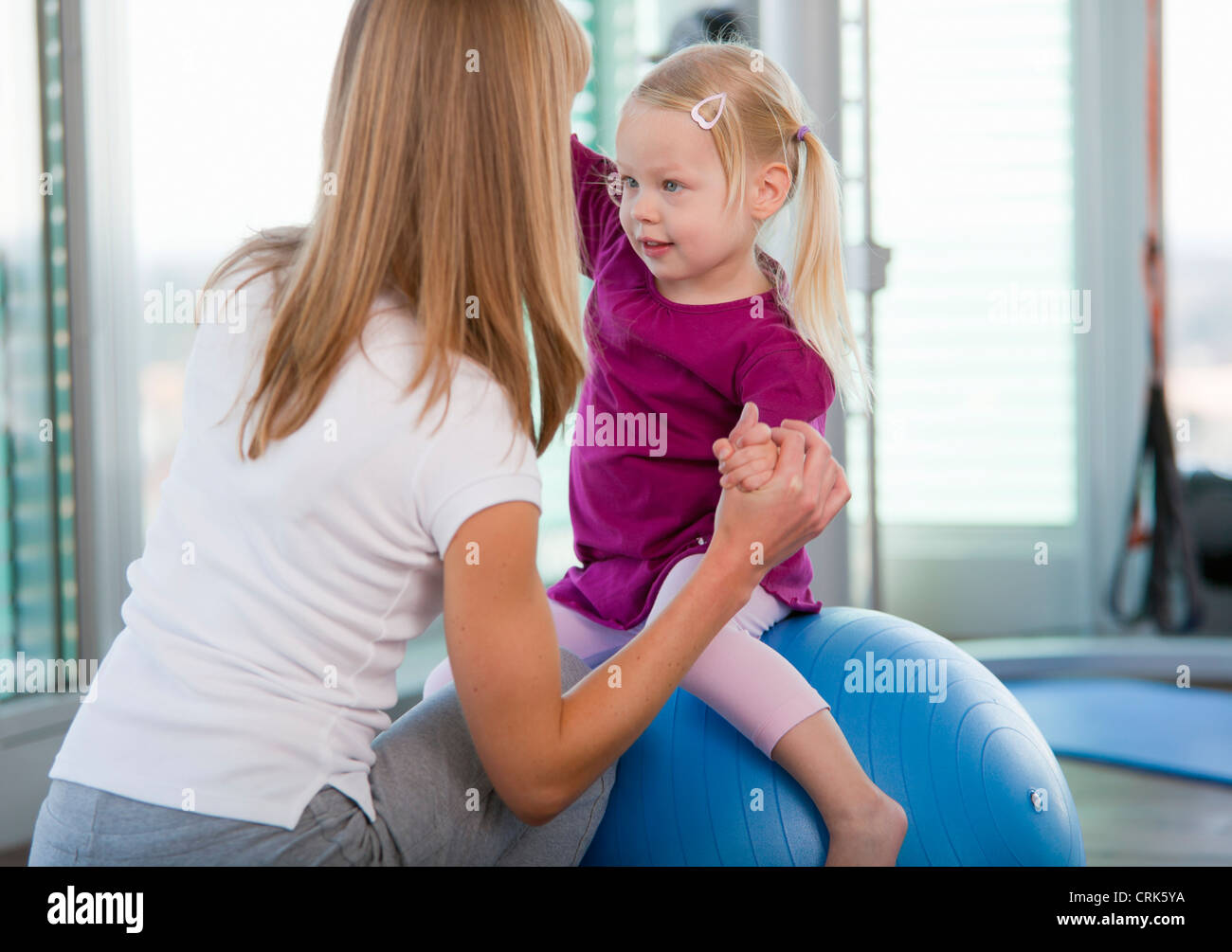 Girls playing with exercise ball in gym Stock Photo Alamy