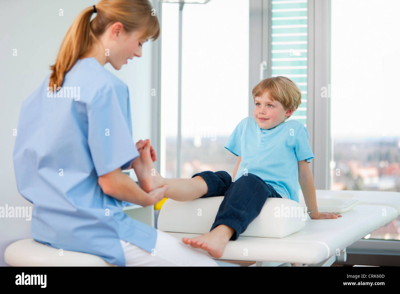 Doctor examining boys feet in office Stock Photo Alamy