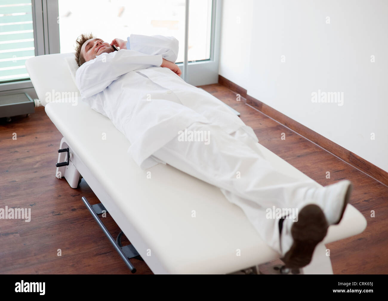 Doctor relaxing on bed in office Stock Photo Alamy