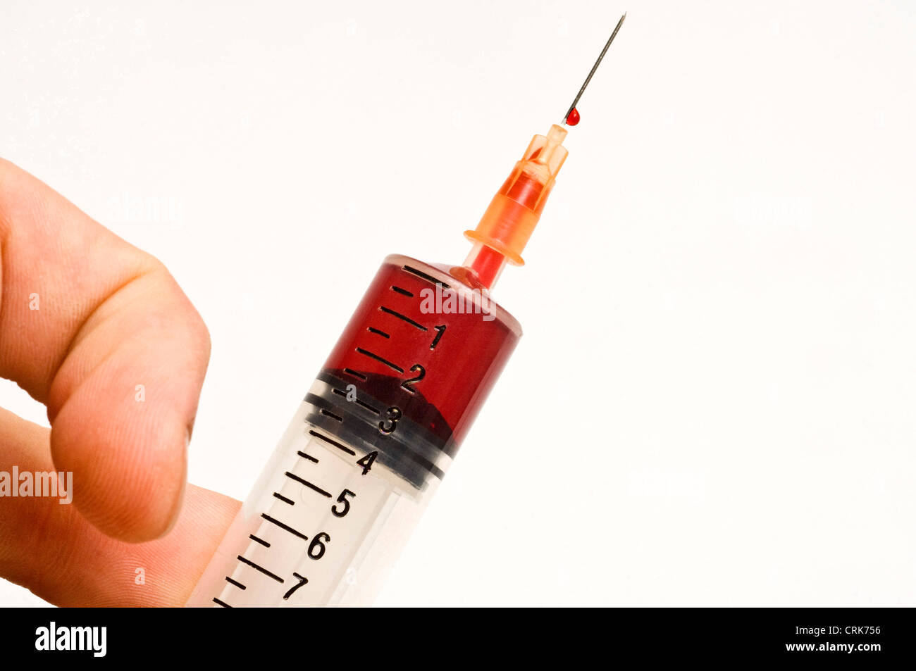 View of a needle attached to a syringe filled with blood Stock Photo ...