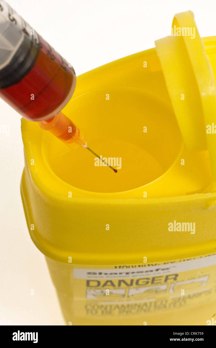 needle with led liquid in and a clinical waste bin Stock Photo