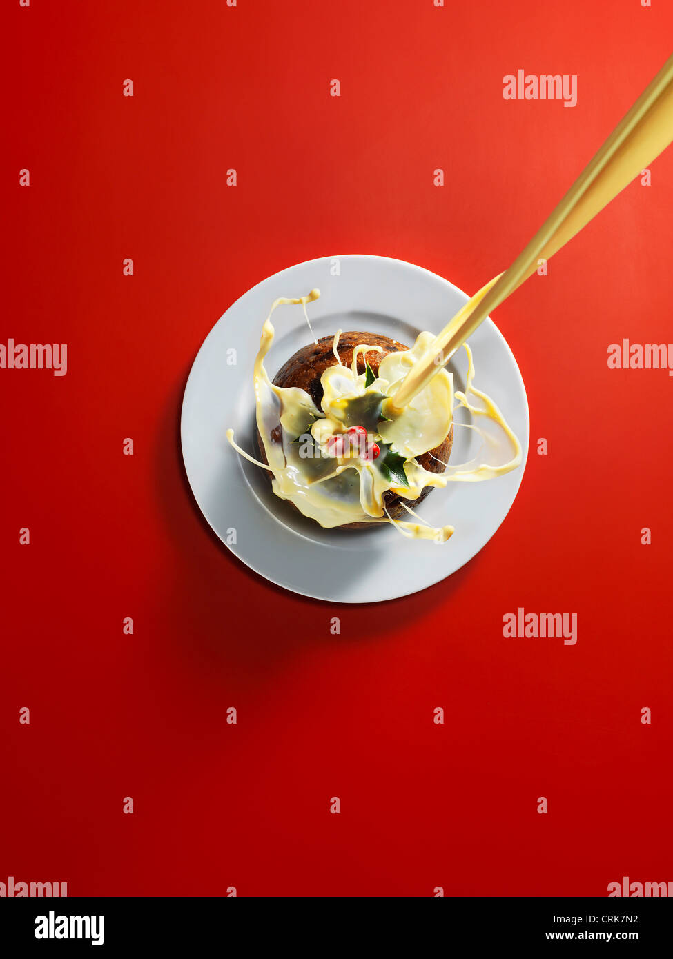 Cream pouring onto Christmas cake Stock Photo