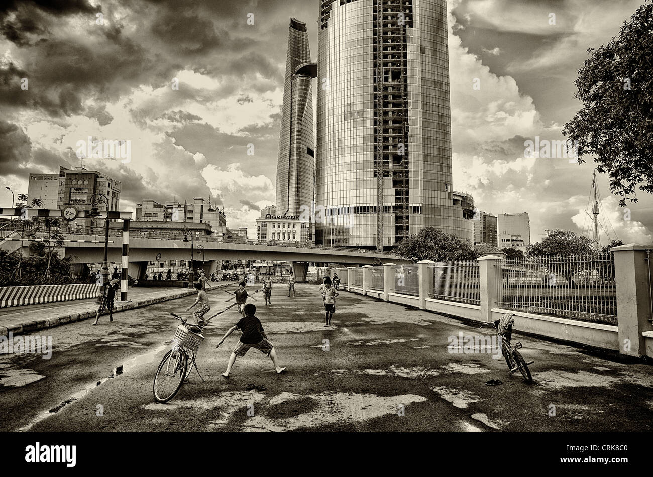 In HCMC, Vietnam, kids are playing football under the skyscrapers in the stormy weather Stock Photo