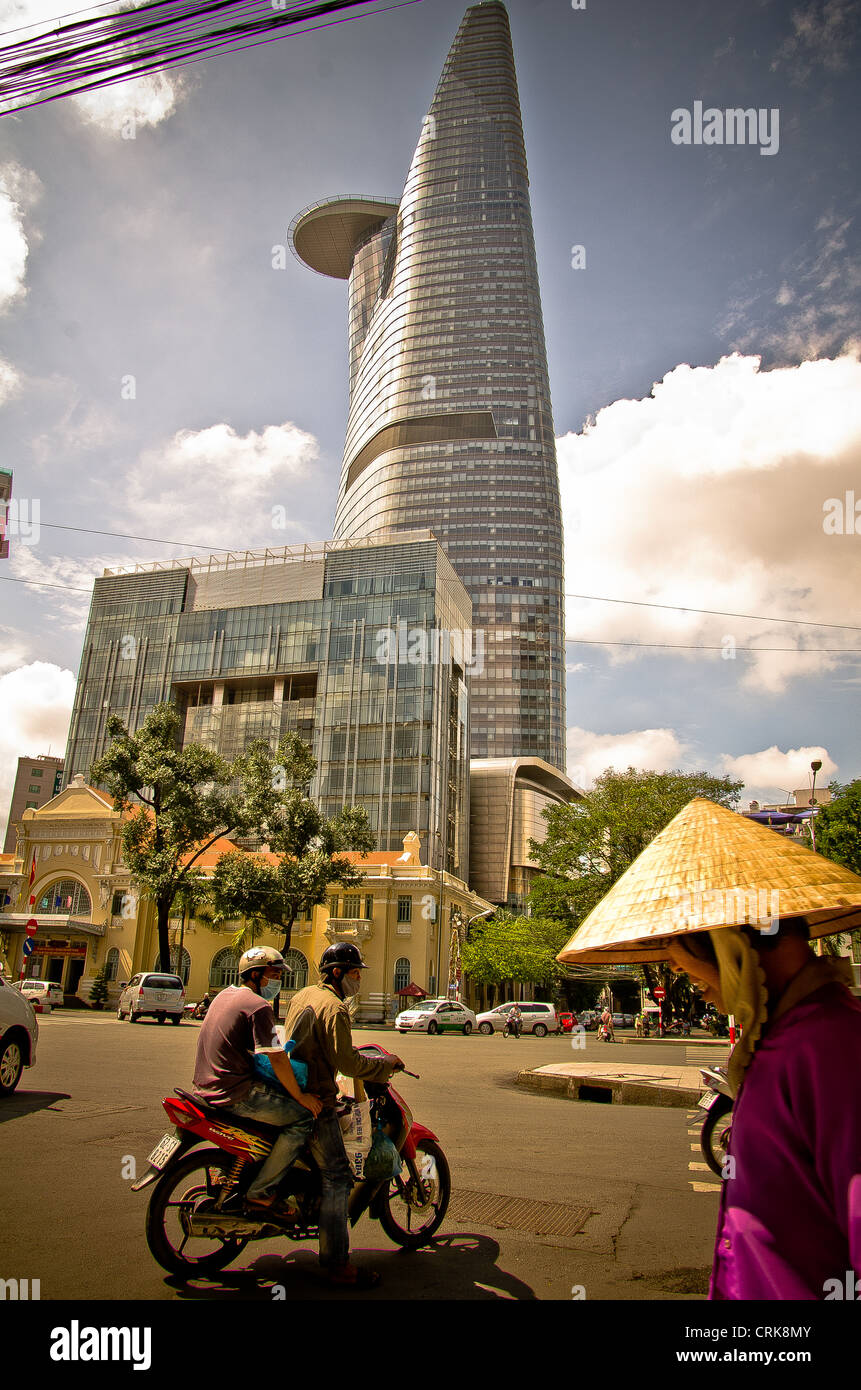 Contrast between a traditional Vietnamese hat and this huge, modern Bitexco Tower. In Dist. 1, HCMC, Vietnam Stock Photo