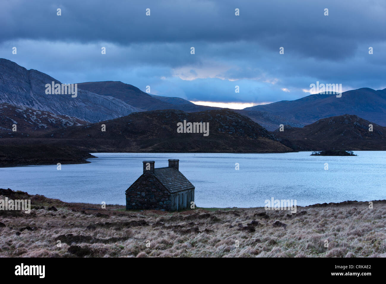 an abandoned crofters cottage by a lochan in Sutherland, Scotland Stock Photo