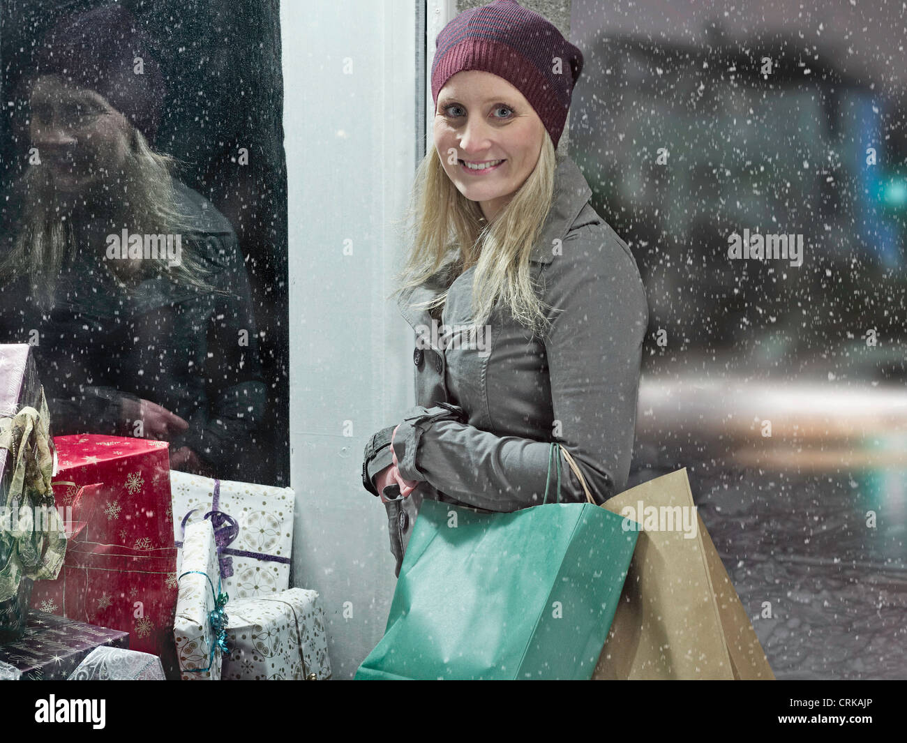 Woman carrying shopping bags in snow Stock Photo