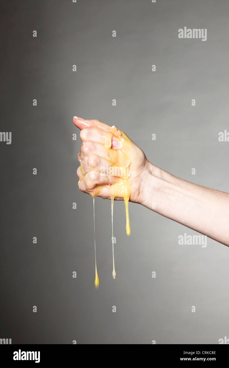 Hand crushing raw egg Stock Photo Alamy