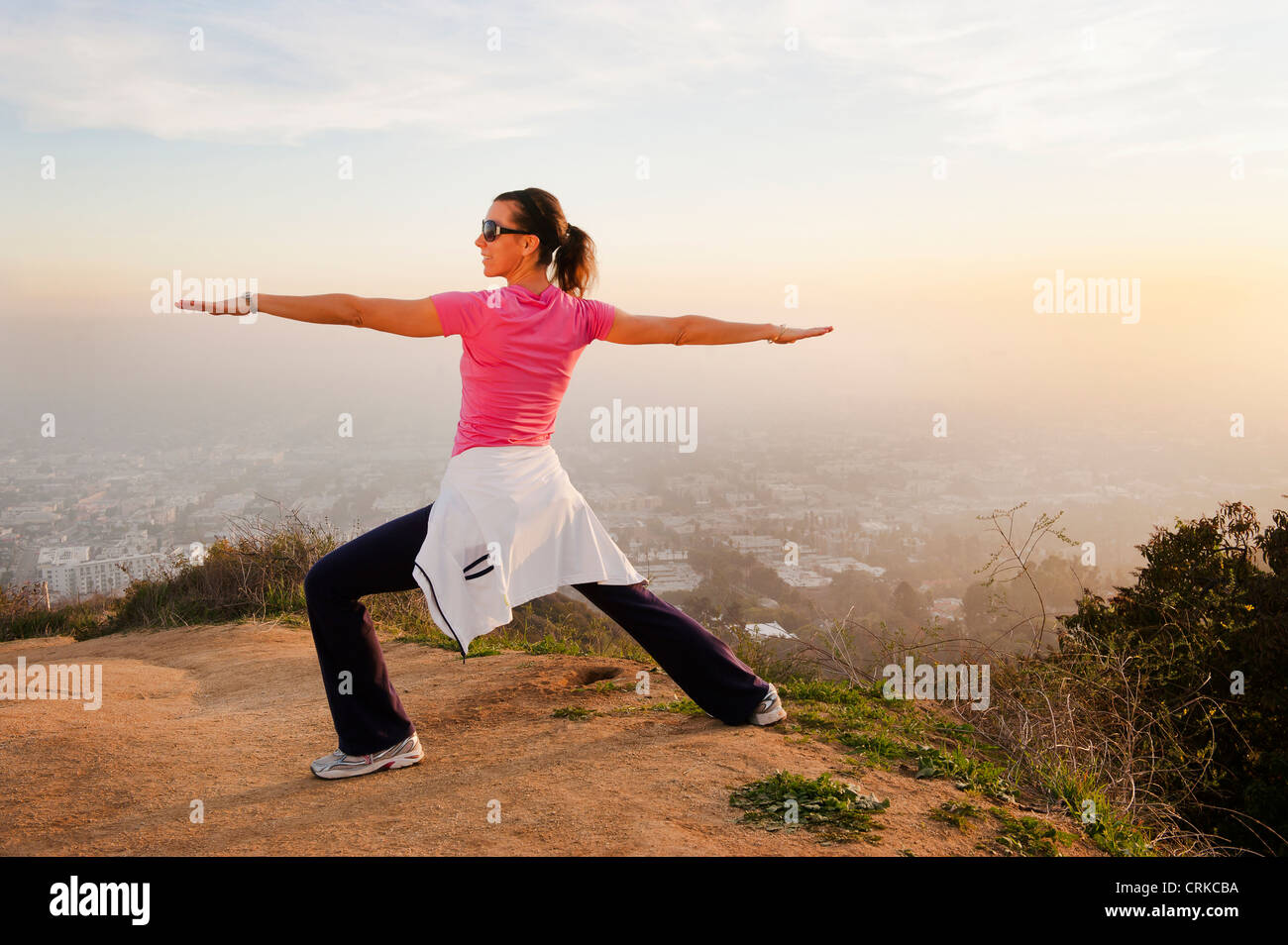 Woman stretching on hilltop Stock Photo