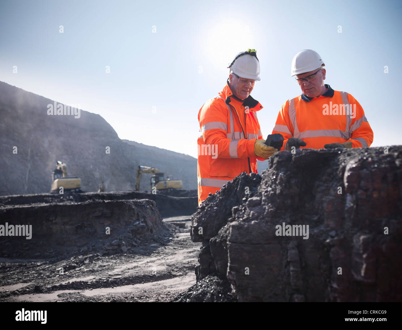 Workers inspecting coal at mine Stock Photo