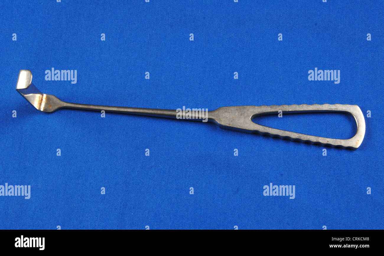Metal Retractor on a blue background Stock Photo