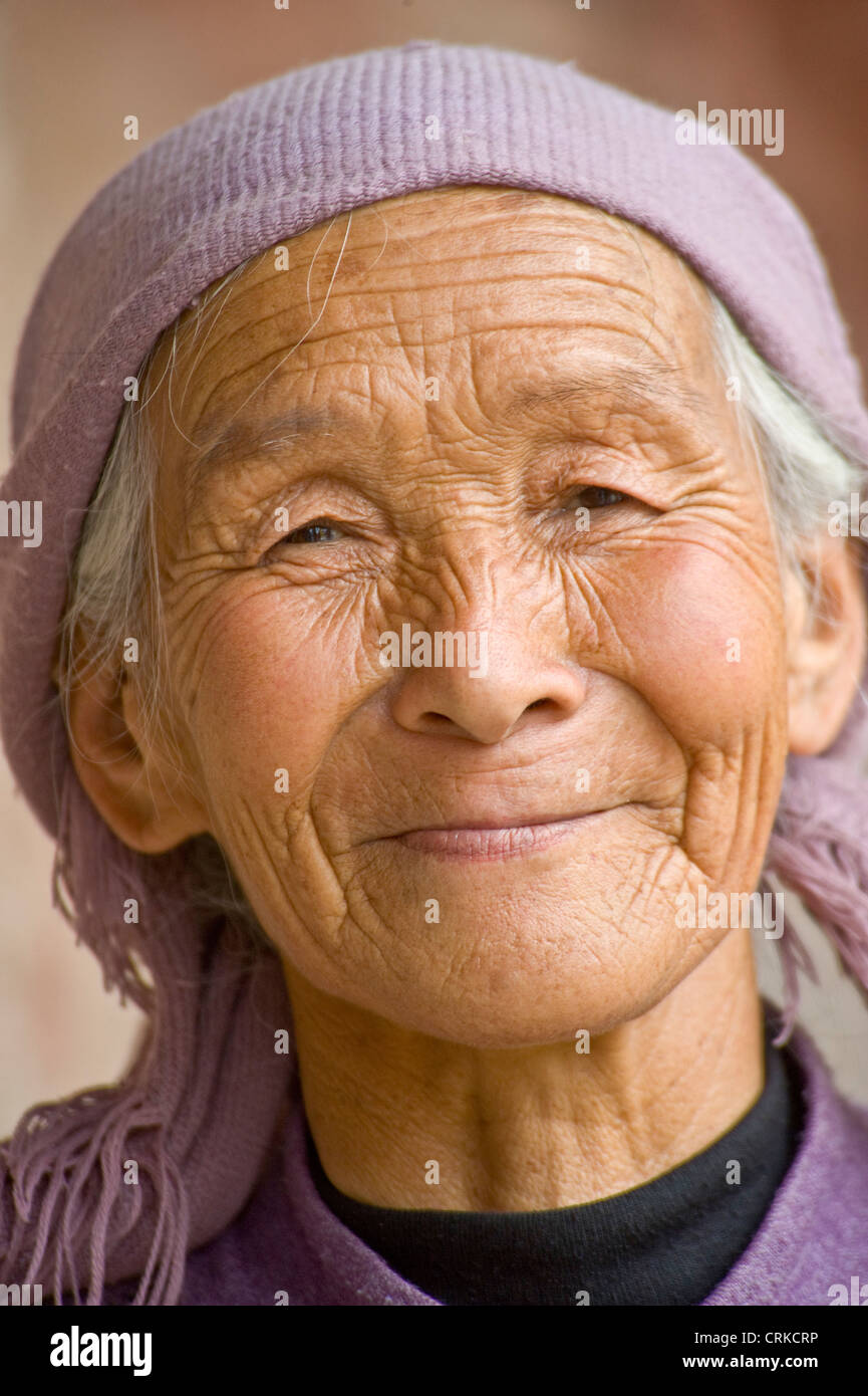 A portrait of a smiling elderly Chinese lady who works at the Bingling Grottoes. Stock Photo