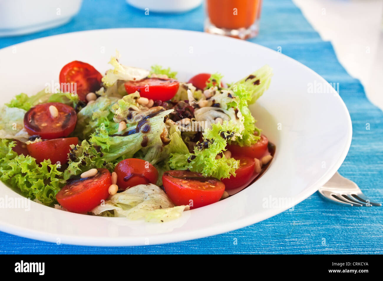 Fresh salad with cherry and lettuce on a blue tablecloth Stock Photo