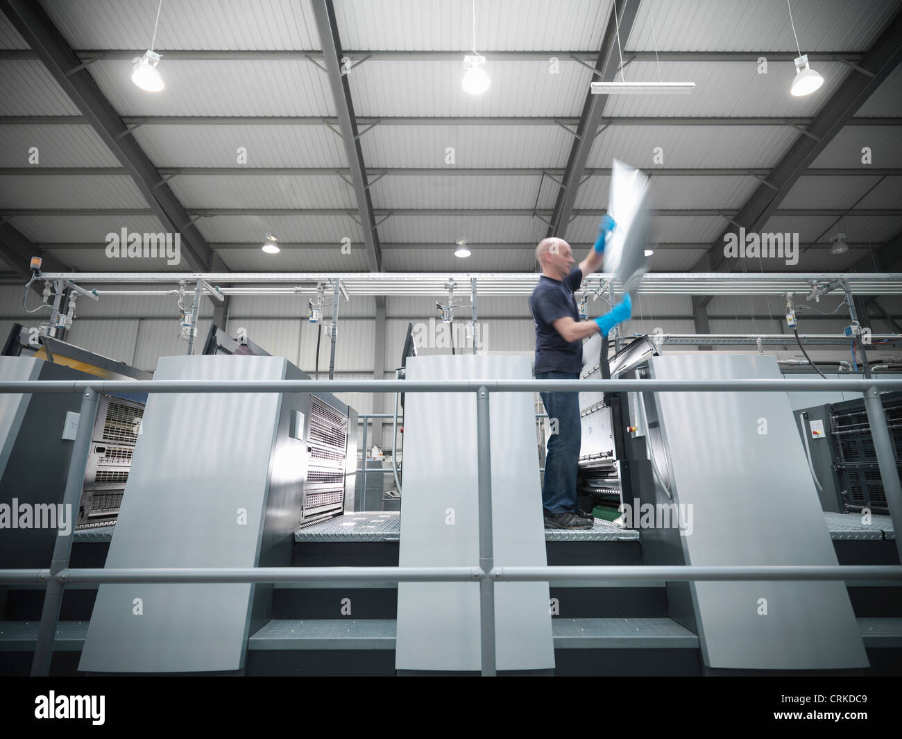 Worker changing plates on printing press Stock Photo
