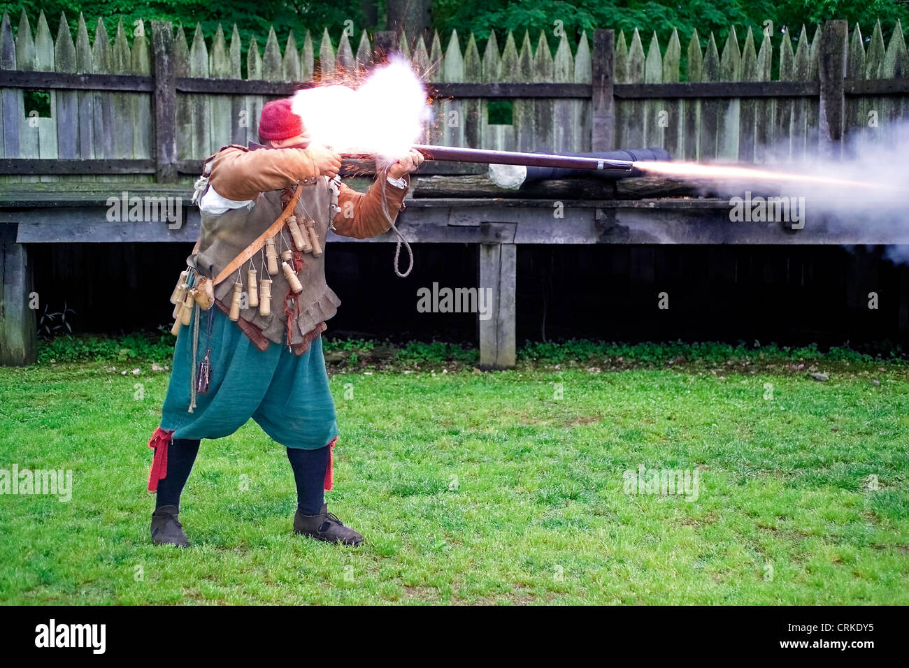A historical interpreter fires a matchlock musket after demonstrating how to load the weapon with gunpowder at Jamestown Settlement in Virginia, USA. Stock Photo